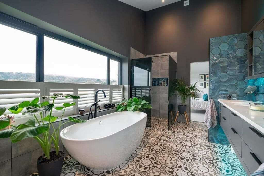 Modern bathroom with a freestanding white tub and patterned floor tiles at Headon Reach luxury timber frame homes Isle of Wight.