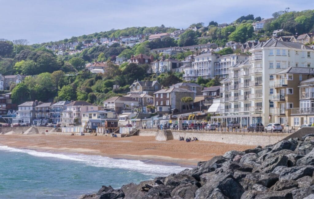 Scenic coastal view of Ventnor beach with the multi-storey timber frame apartments situated on the hillside above.